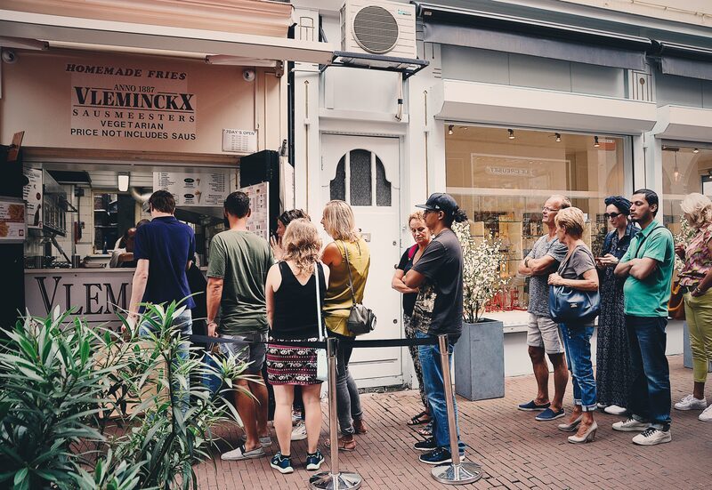 De Voetboogstraat met de rij bij Vleminckx, een paar deuren verderop