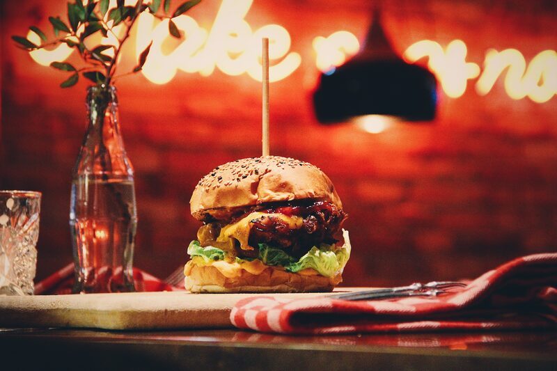 Kipburger op de bar met het neonbord op de achtergrond