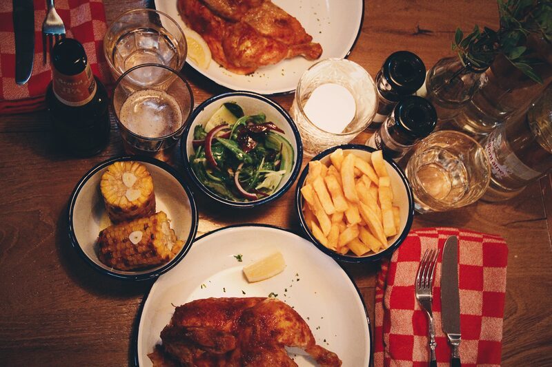 A shared table: rotisserie chicken, Vleminckx fries, corn and salad